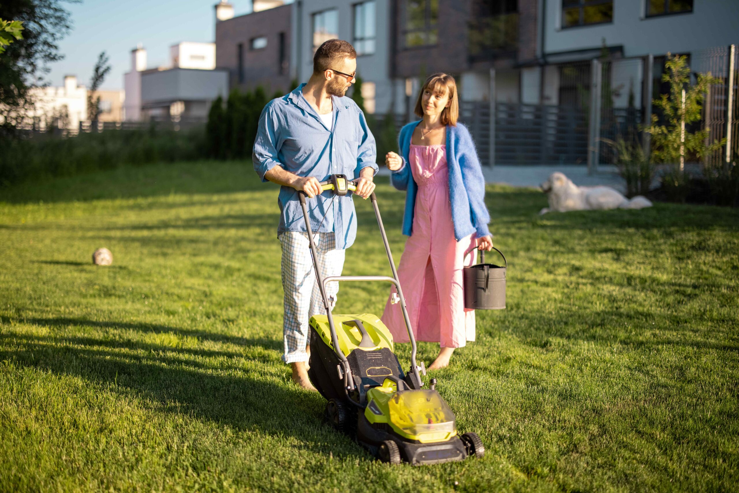 Young family take care of lawn on summer evening
